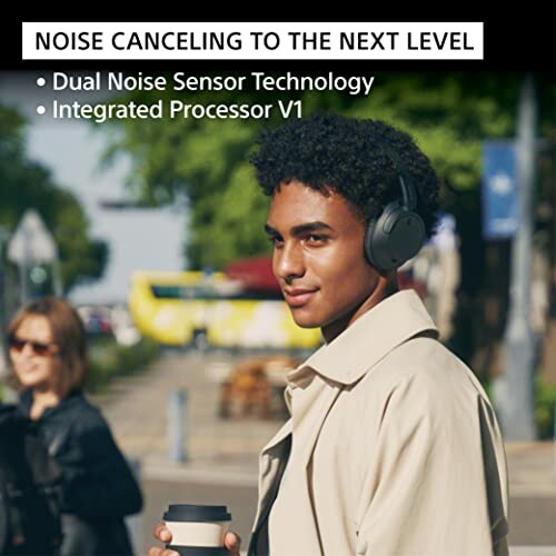 Person wearing noise-canceling headphones on a street.